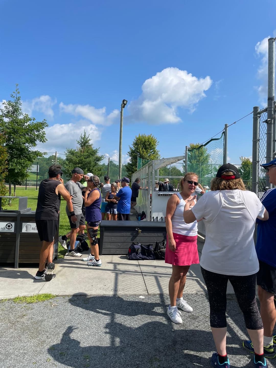 Membres du club Pickleball Sutton qui attendent leur tour pour jouer une partie de pickleball.